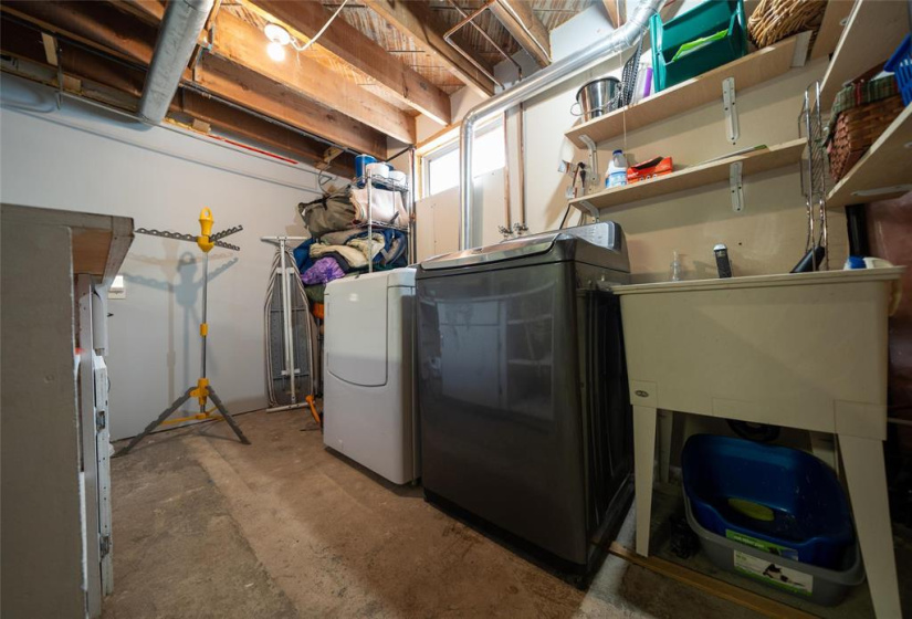 Laundry with sink and built-in shelving.