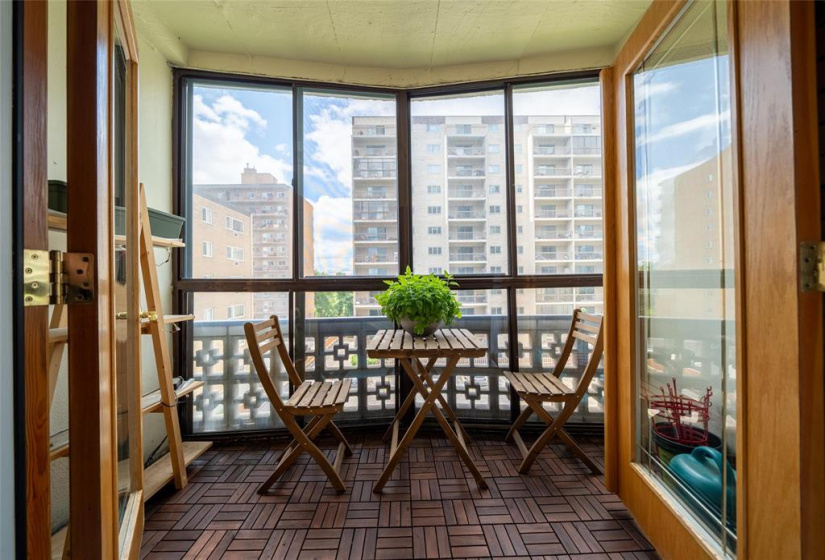 Glass enclosed balcony with interlocking wood decking.