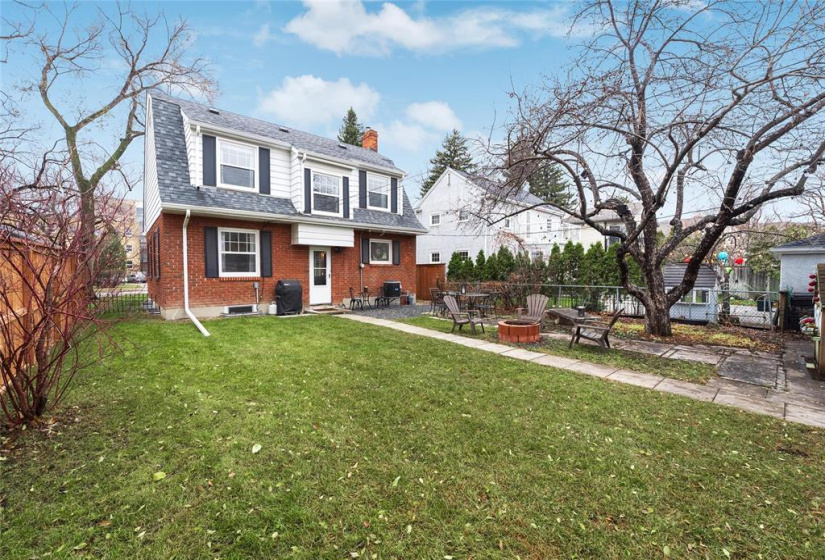 View of back of the home. Fire pit included. Concrete bench stays. Air conditioner 2012