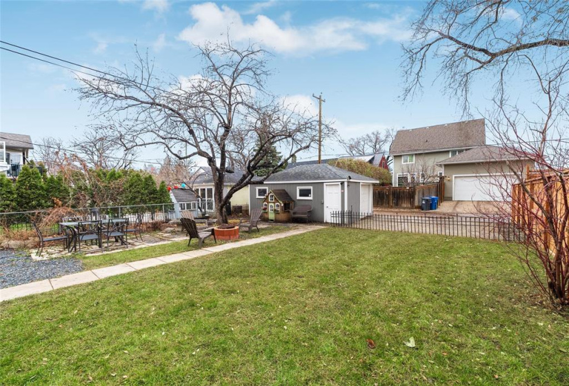 Patio area. Play house can stay or go. Oversized single detached garage and extra parking area