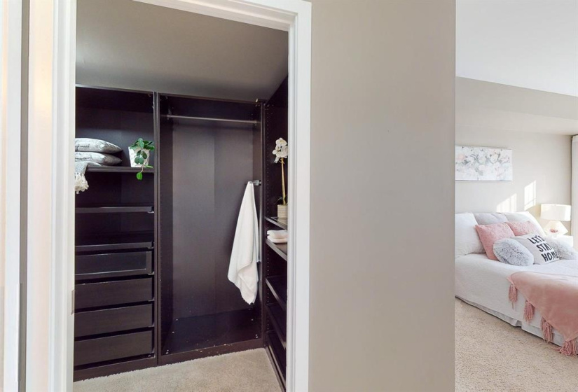 LARGE SPACIOUS WALK IN CLOSET IN THE PRIMARY BEDROOM, WITH TONS OF RACKS TO HANG CLOTHING AND PULL OUT SHELVES. THIS CUSTOM BUILT INSERT FROM IKEA COST $5000 TO HAVE INSTALLED AND SET UP IN HERE.