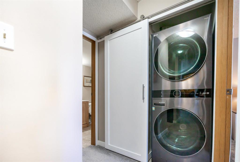 High-end laundry appliances are tucked away behind a sliding barn style door